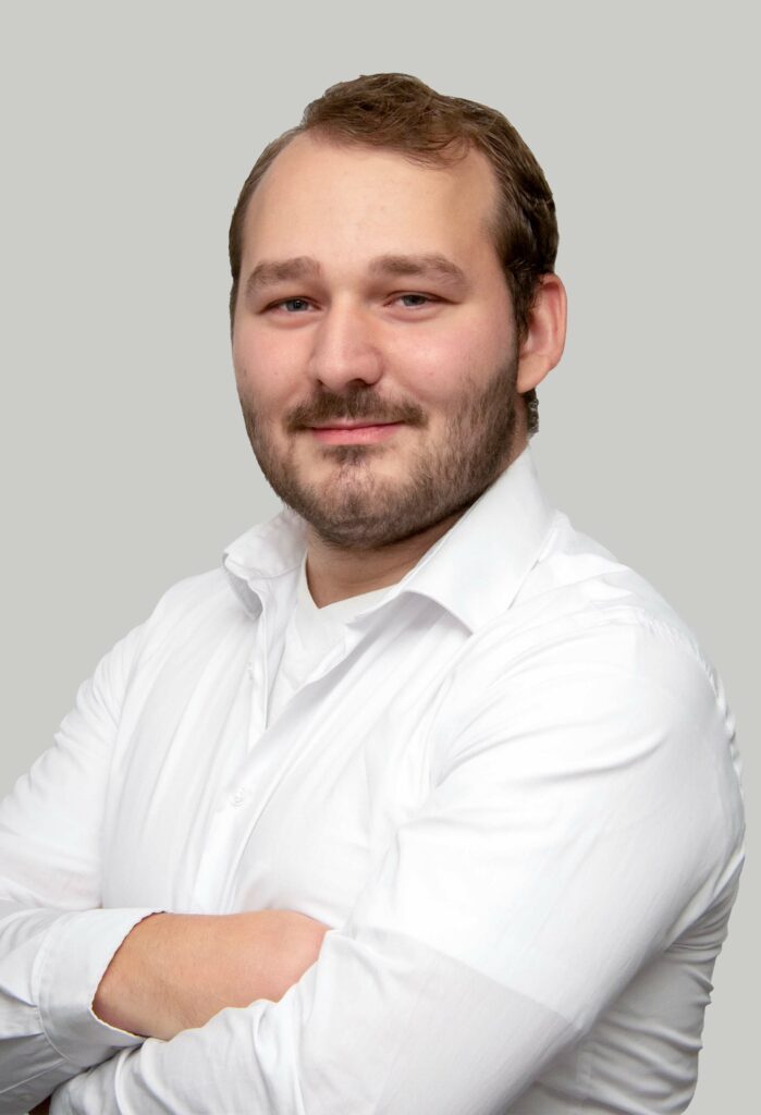 Bartträger mit weißem Hemd, selbstbewusst.