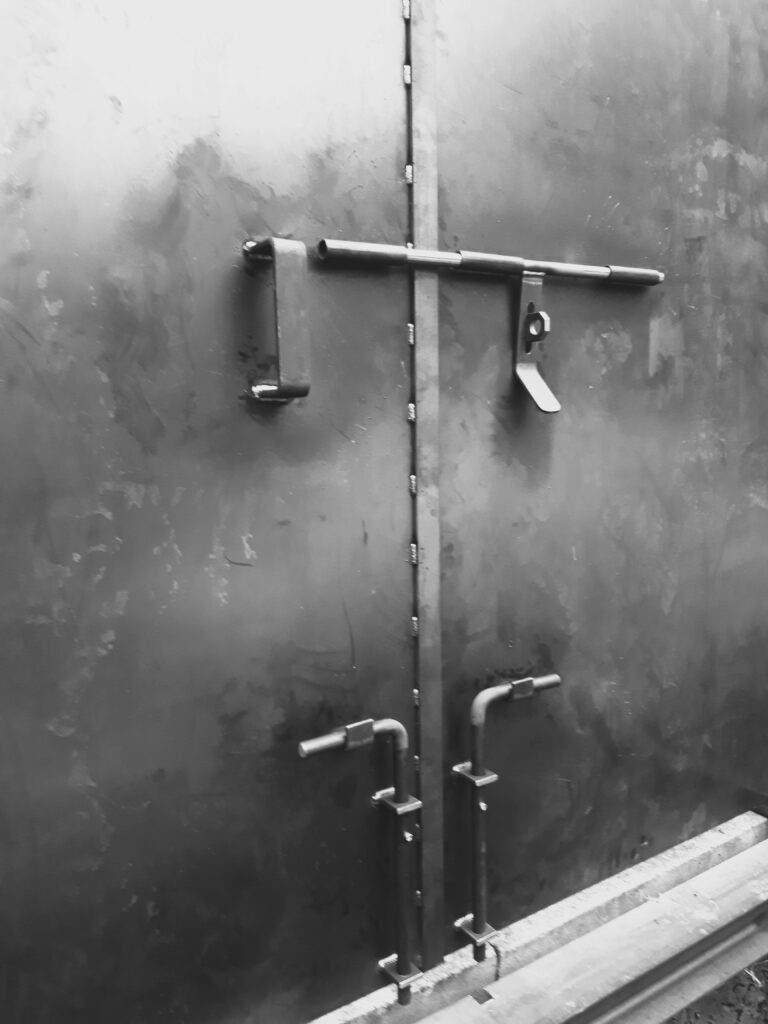 Schwarze Metalltür mit Schubriegeln.