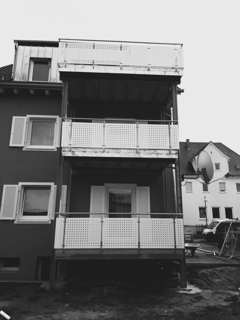 Drei Balkone, monochrome Häuserfassade.