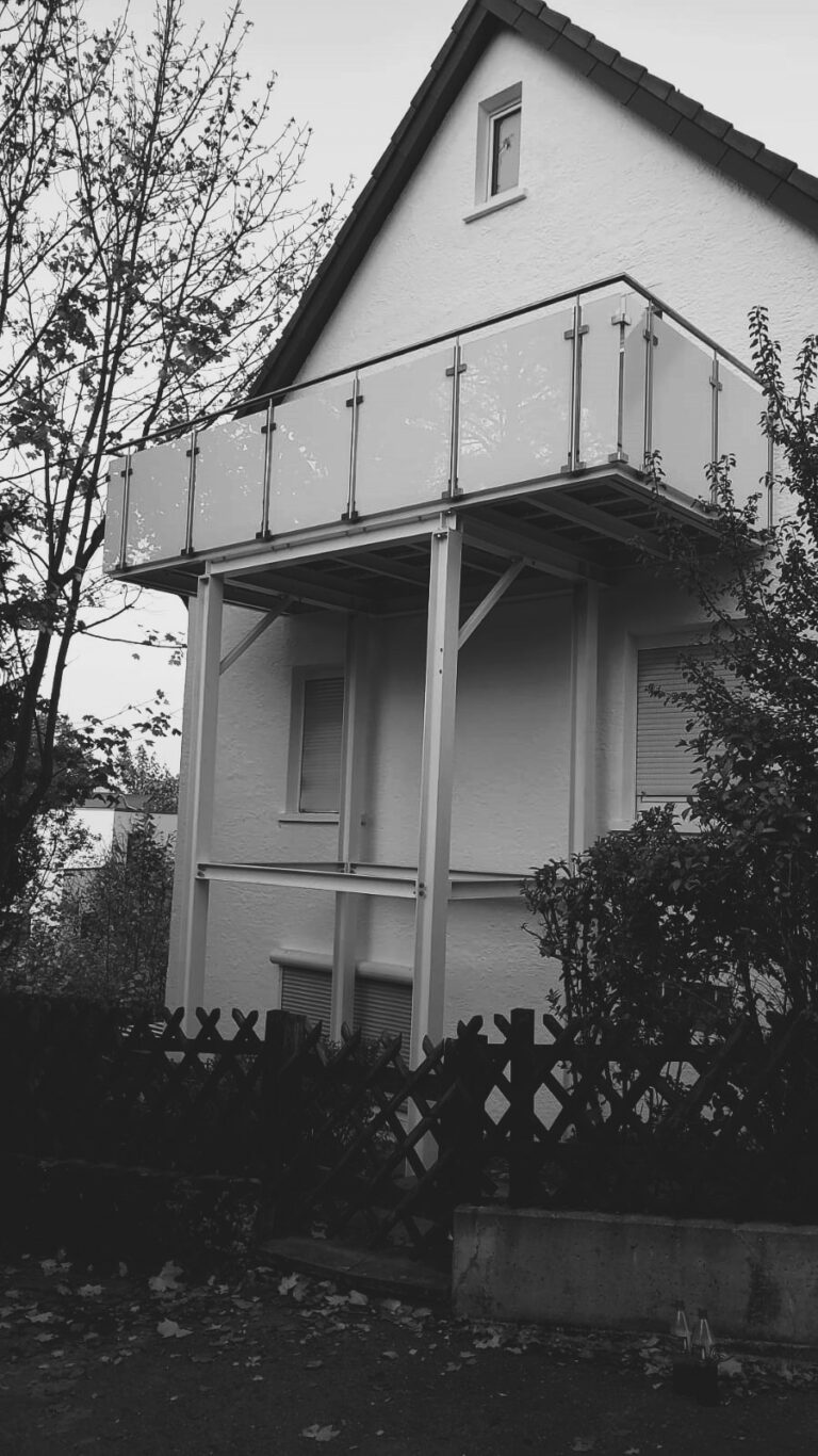 Balkon mit Glasgeländer, Herbstlaub