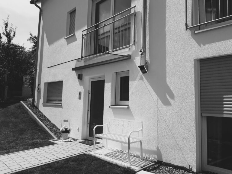 Weiße Bank, moderner Hauseingang, Schatten.