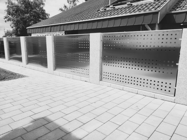 Metallzaun mit quadratischen Durchbrüchen.