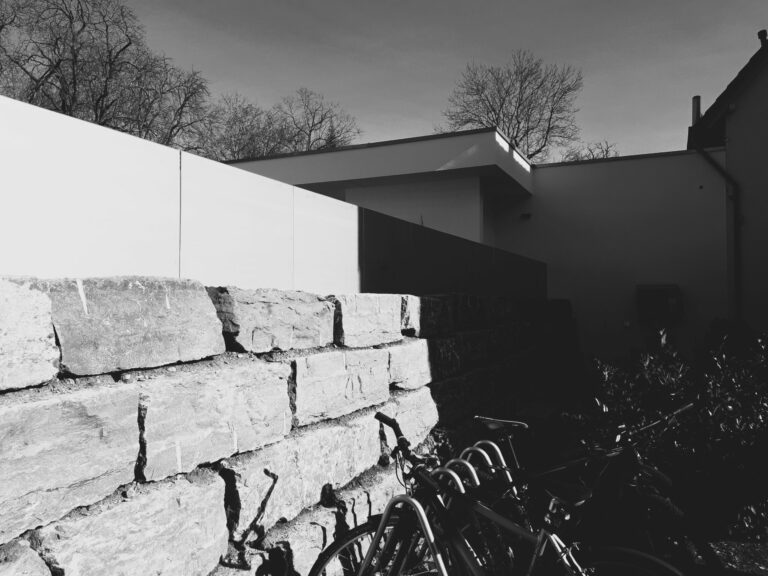 Fahrräder, Steinmauer, Schatten, moderne Architektur.