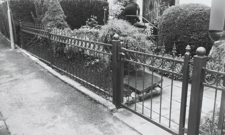 Gusseisernes Tor, gepflegter Vorgarten, Person